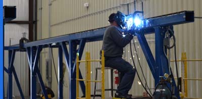 Welder Modifying Aircraft Inspection Gantry